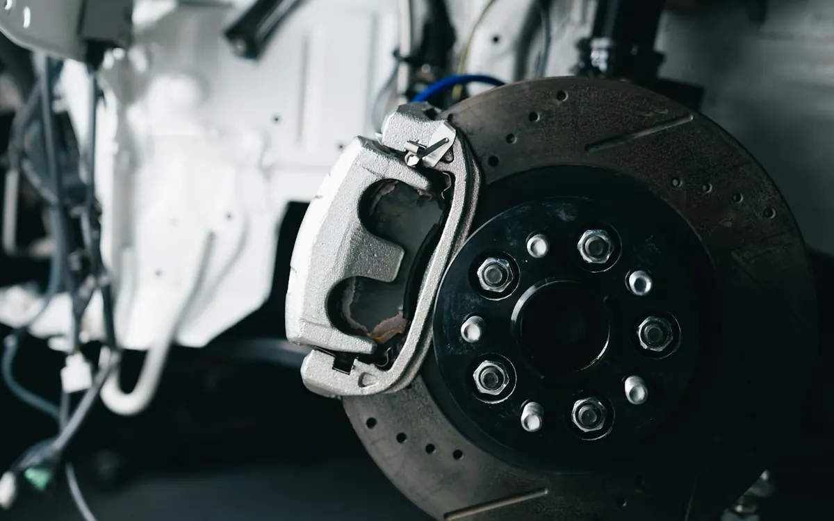 Close-up of a drilled brake rotor and caliper during brake work — South OC brake repair help